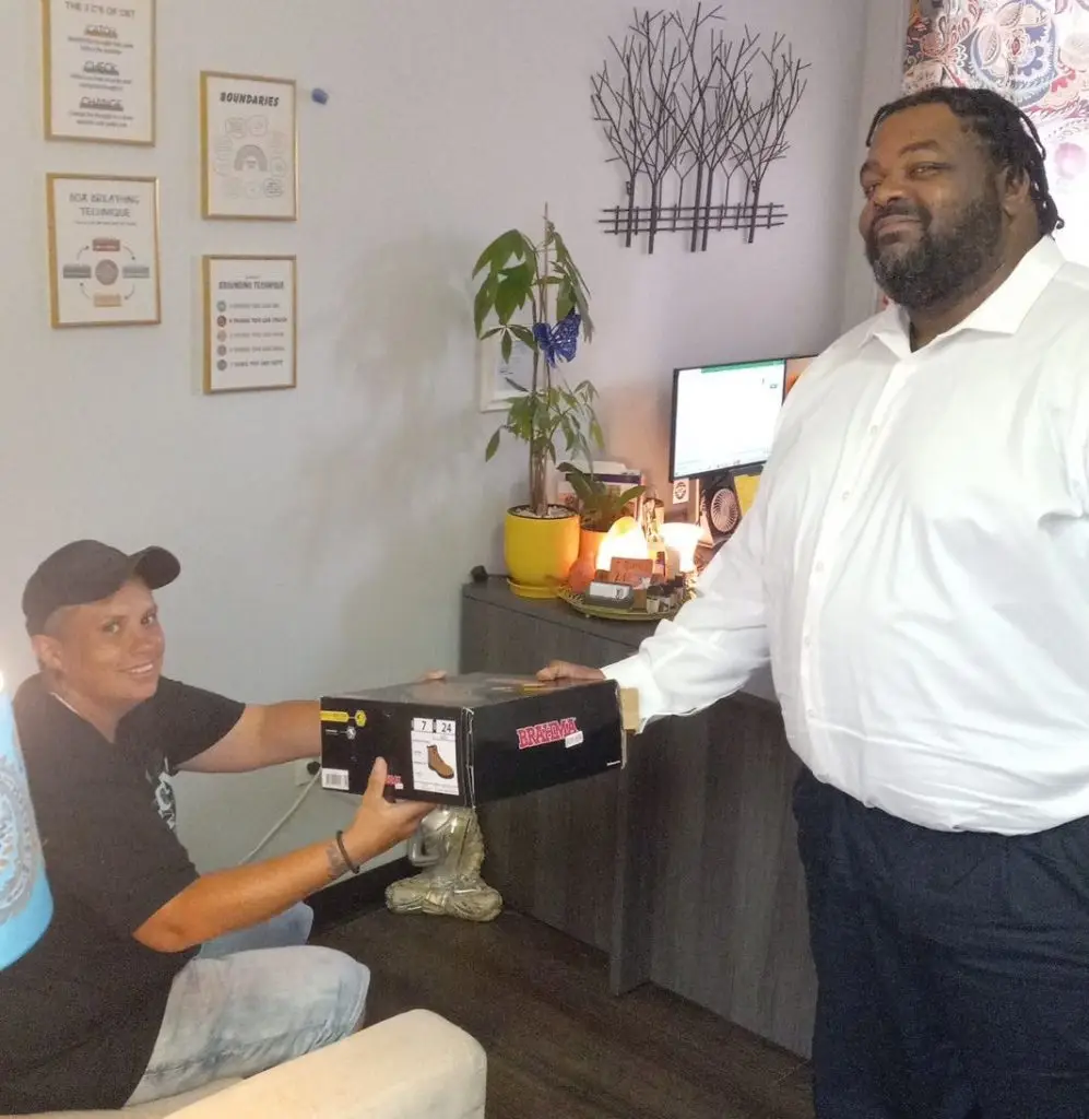 After completing FDOT Certification Training Academy, Ready4Work client Jessica M. receiving steel toe boots form Turner Construction for work